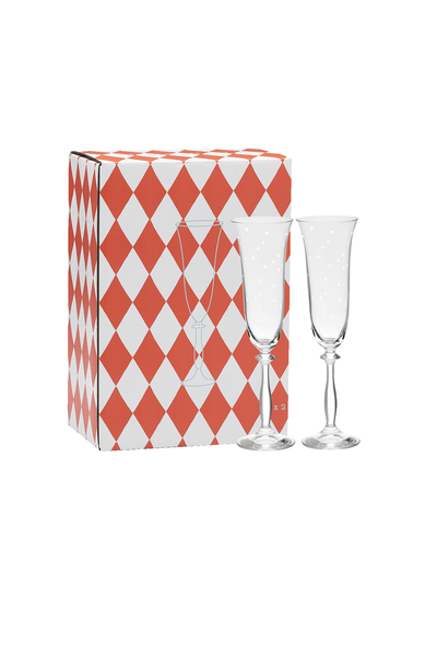 Two clear champagne flutes in front of a red and white checkered box on a white background