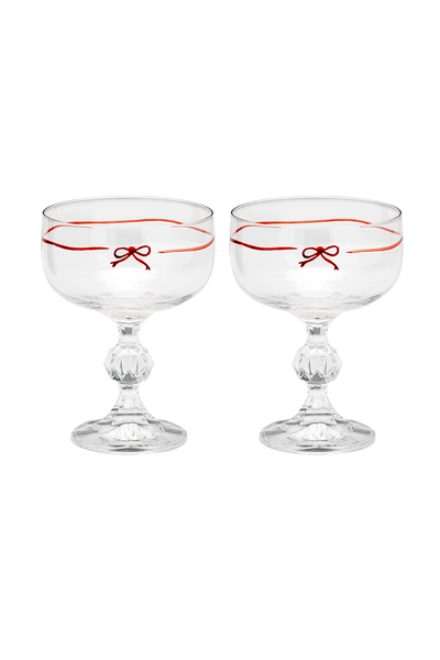 Two clear glass coupes with red ribbon designs on a white background