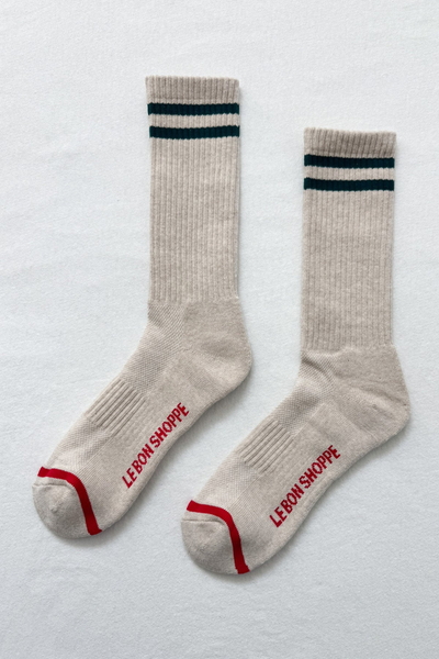 Pair of beige socks with blue and red accents on a light gray background