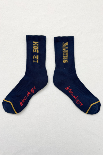 Pair of navy blue socks with gold and red text on a light gray background